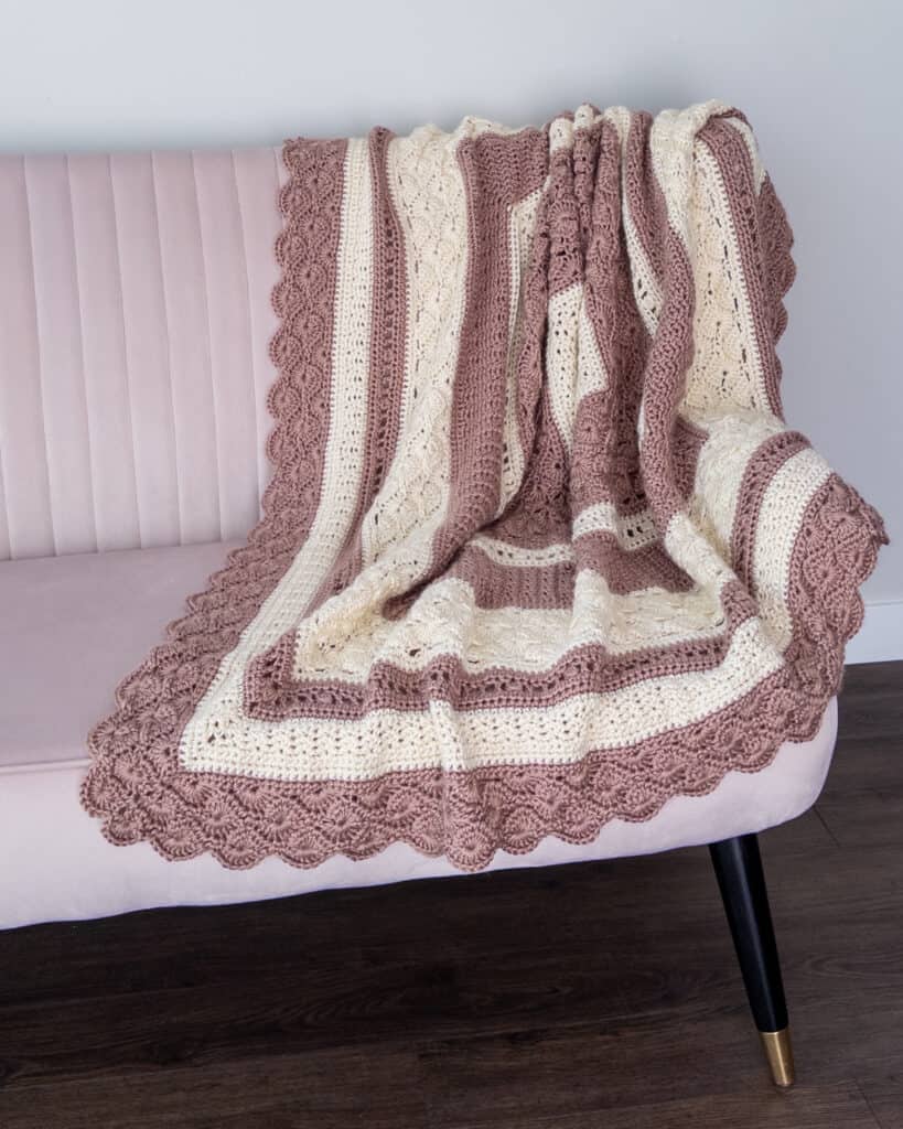 Crochet blanket draped on a light pink couch