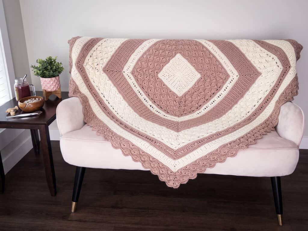 Shell & Lace Throw Blanket on the back of a light pink couch