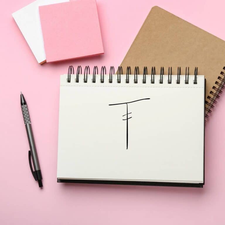 Hand drawn treble crochet symbol on a notebook. on a pink background.